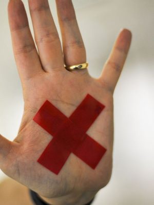 O sinal “X” feito com batom vermelho (ou qualquer outro material) na palma da mão ou em um pedaço de papel, o que for mais fácil, permite que a pessoa treinada reconheça que aquela mulher foi vítima de violência doméstica e, assim, acione a Polícia Militar.